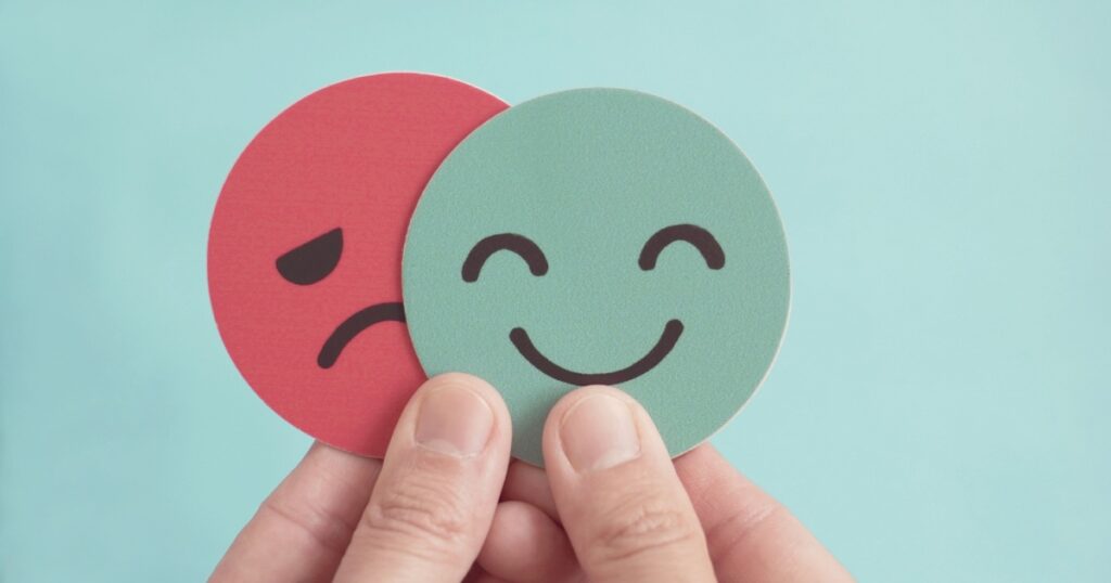 Hands holding happy and angry face paper, feedback rating , customer review, Emotional intelligence, balance emotion control,mental health assessment, bipolar disorder concept