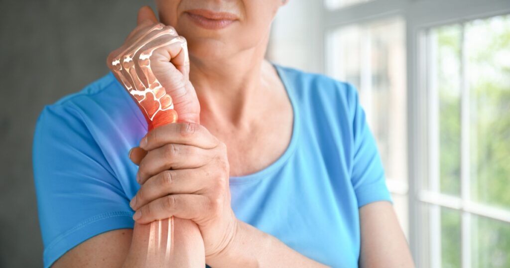 Mature woman having pain in wrist at home