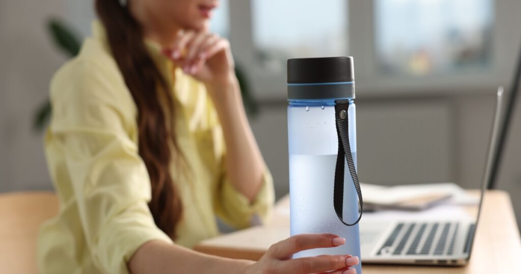 https://www.shutterstock.com/image-photo/woman-holding-transparent-bottle-workplace-indoors-2220872153