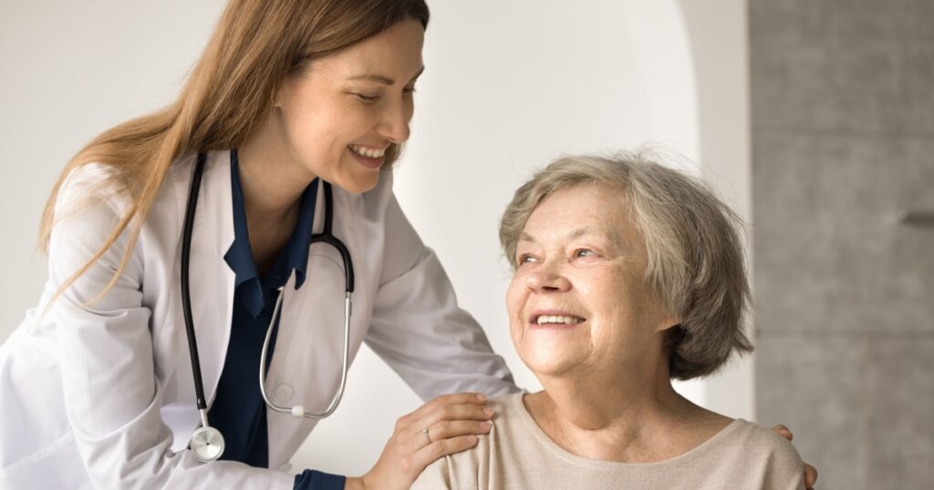 Friendly young female doctor give support to retired woman congratulate on recovery, express care and understanding. Happy senior satisfied by good medical services in hospital. Geriatrics, healthcare
