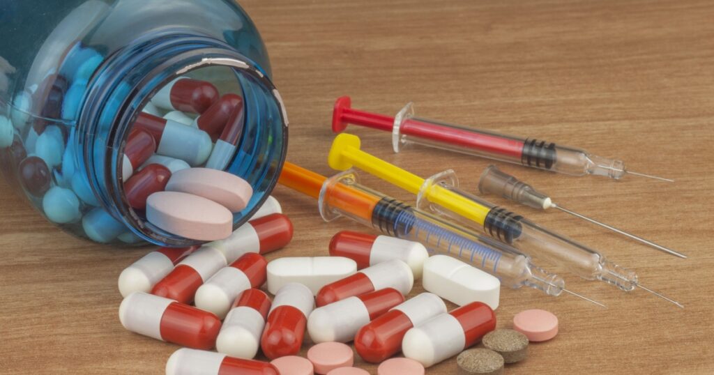 Doping in sport. Abuse of anabolic steroids for sports. Anabolic steroids spilled on a wooden table. Fraud in sports. Pharmaceutical industry. Detailed view of the medication. Place for your text.