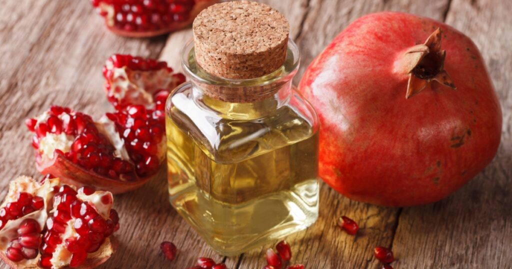 Pomegranate seed oil in a glass bottle on a table close-up. Horizontal