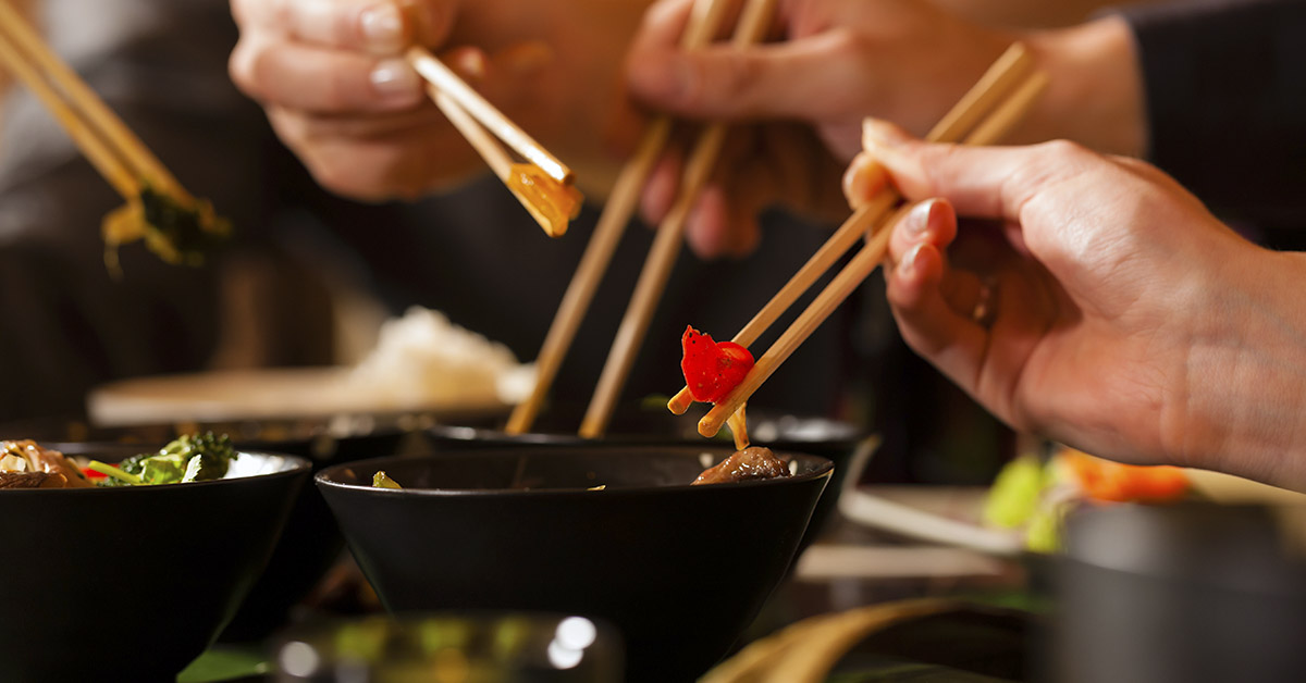 People using chopsticks to eat food. Asian/Chinese Food concept