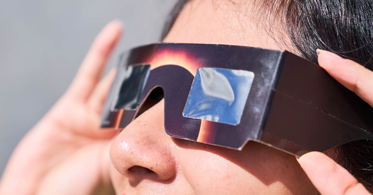 woman looking at eclipse using protective eye ware