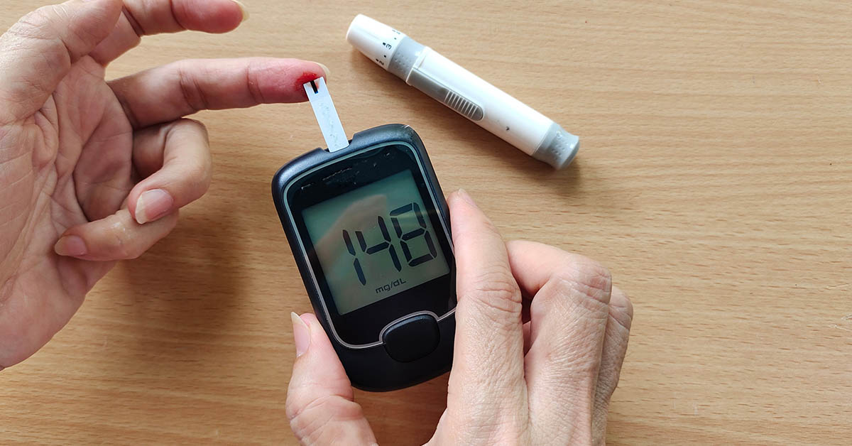 person checking blood sugar levels using glucose meter