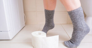 30 Cancer Survivors Share Subtle Signs They Knew Something Was Off person on toilet. Toilet paper on bathroom floor at their feet