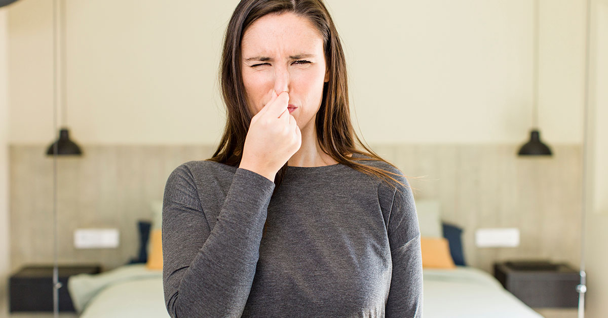 woman holding nose due to foul odor. Farting, flatulence concept