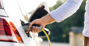 20 Issues With Electric Vehicles (EVs) That Owners Complain About The Most person placing charger into EV