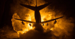 passenger jet flying through clouds in front of sun