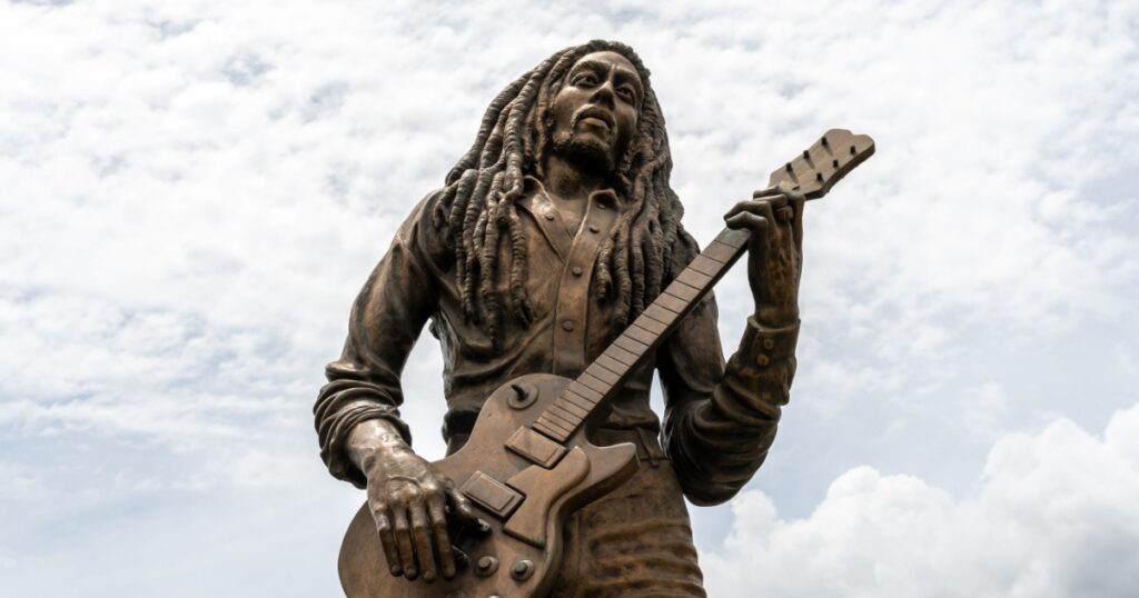Kingston/St Andrew, Jamaica - May 21 2019: Kingston, Jamaica. Bob Marley reggae musician life sized bronze statue. Legend celebrity ambassador monument sculpted by Alvin Marriott by National Stadium.