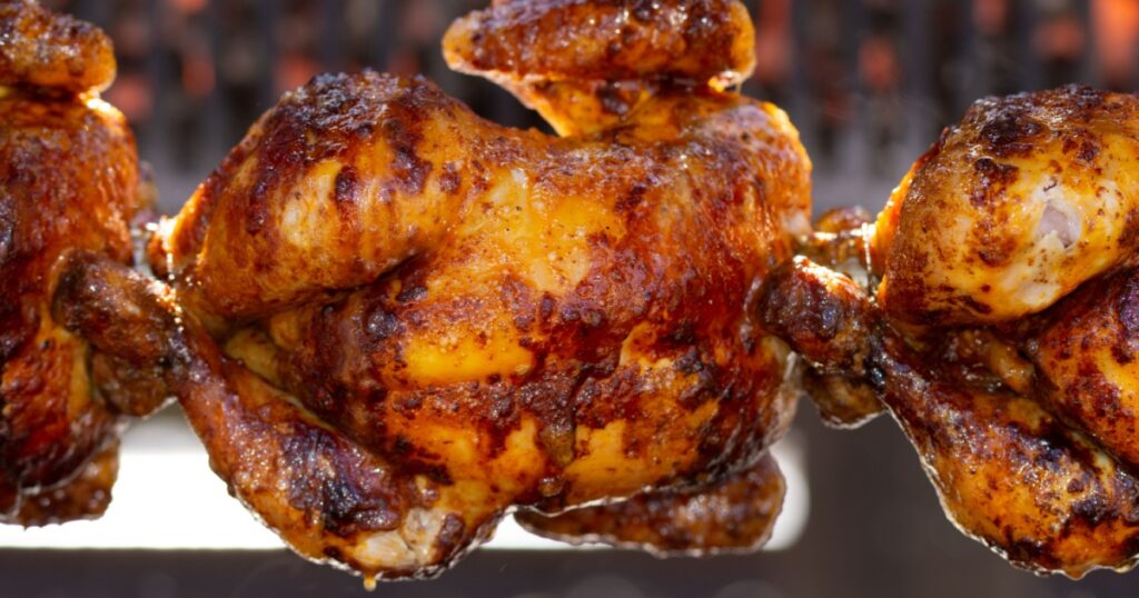 Rotisserie Chicken ,Roasted chickens on spit grilled over fire of a big barbecue,