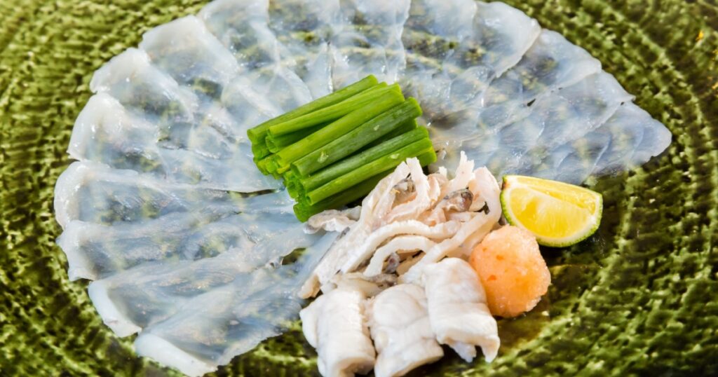 Fugu sashimi and fugu's entrails are in the green plate