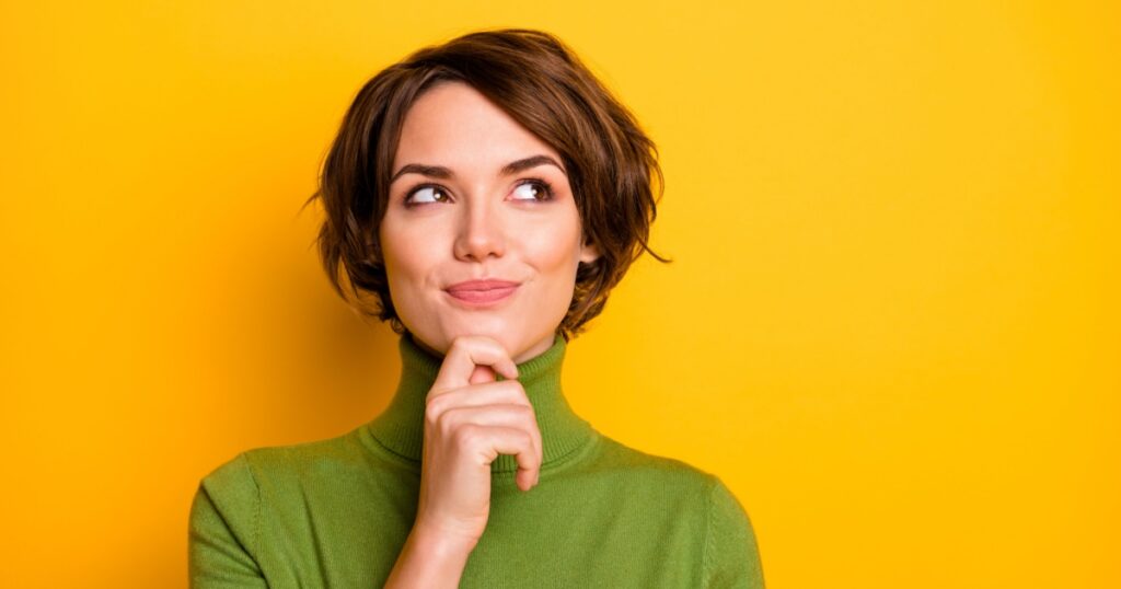 Closeup photo of amazing short hairdo lady looking up empty space deep thinking creative person arm on chin wear casual green turtleneck isolated yellow color background
