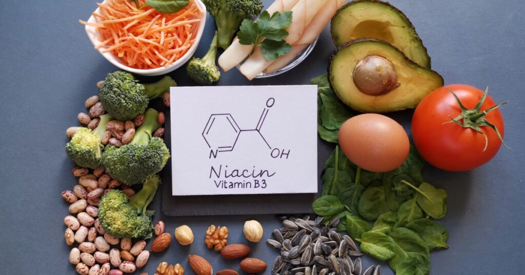 Foods rich in vitamin B3 (niacin, nicotinic acid) with structural chemical formula of niacin molecule. Natural sources of vitamin B3: avocado, nut, spinach, bean, broccoli, egg, tomato, chicken breast