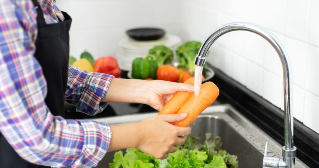 healthy girl Washing vegetables in the kitchen sink