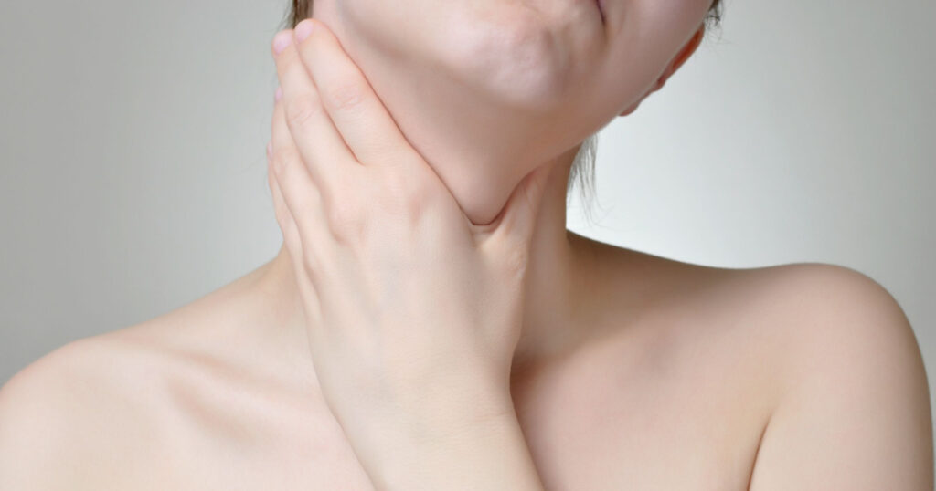 Young woman holding her painful throat