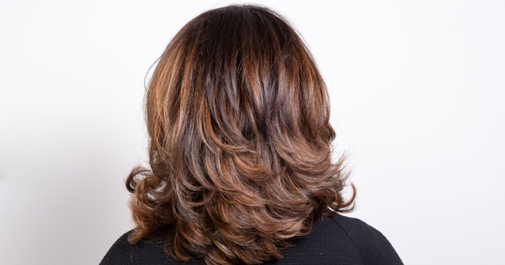 Back view portrait of beautiful dark blonde woman against white background. Lots of Layers
