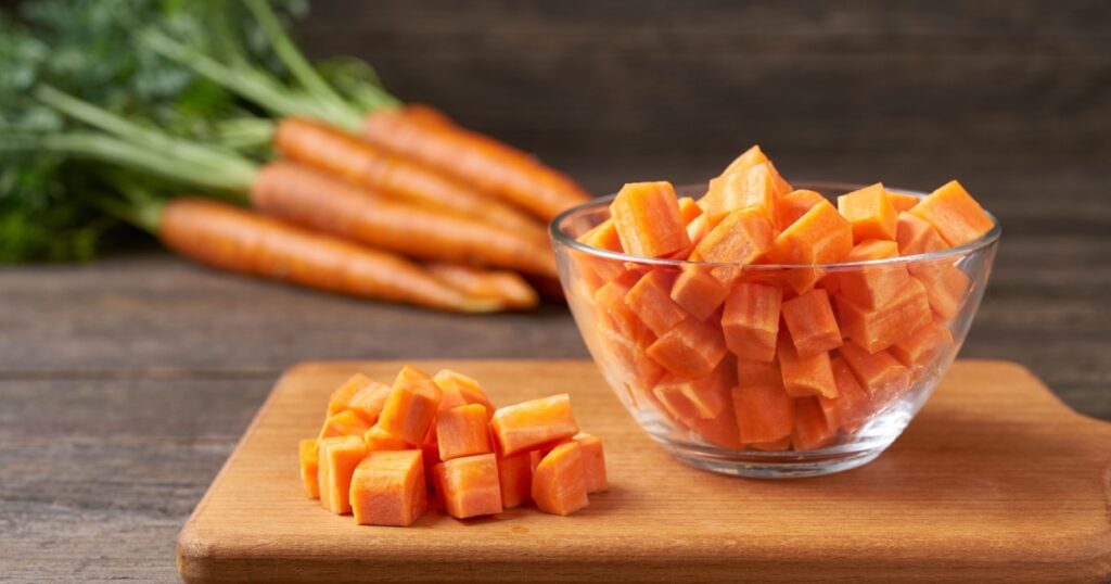 diced carrots on a wooden table, selective focus, rustic style.dice carrots.