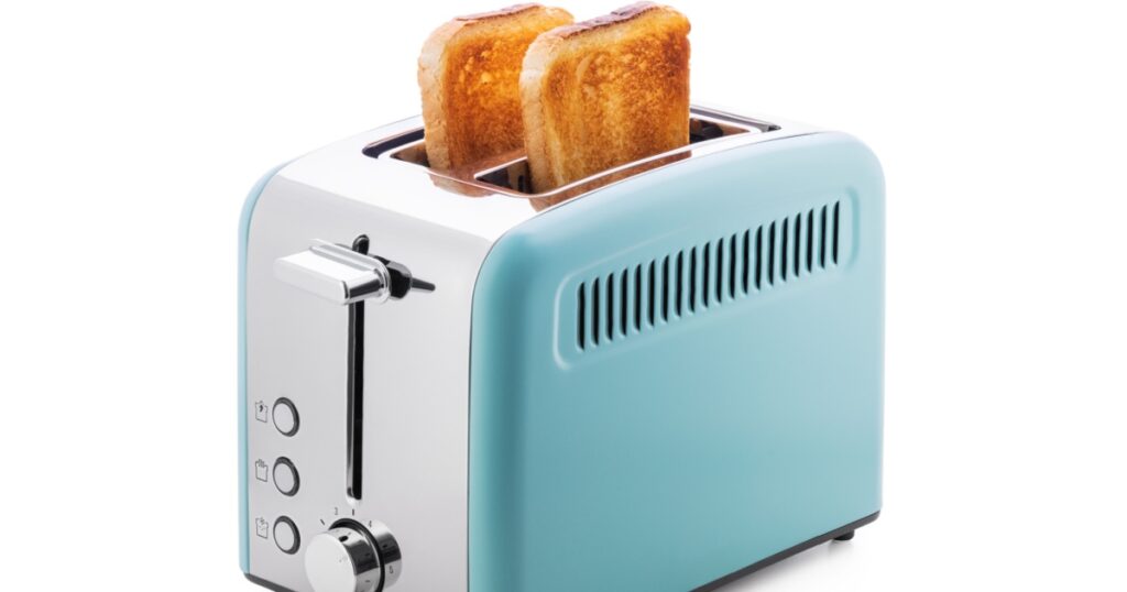 Modern blue toaster with toasted bread for breakfast inside, isolated on white with clipping path.