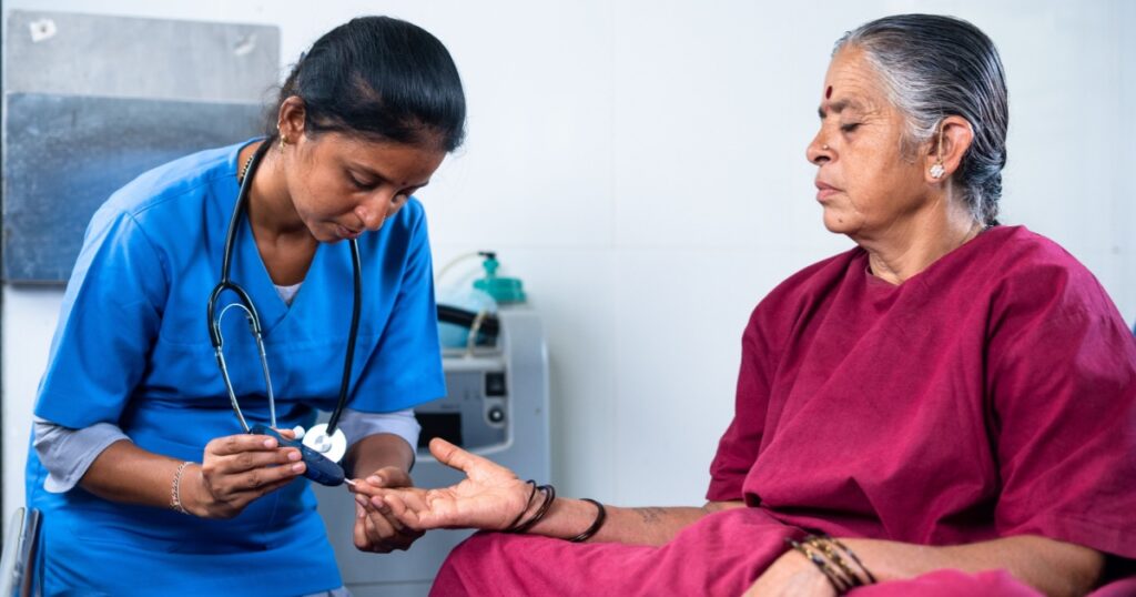 doctor or nurse checking sugar or diabetes level of hospitalised sick woman in operation gown bed - concept of health monitoring and treatment and professional occupation.