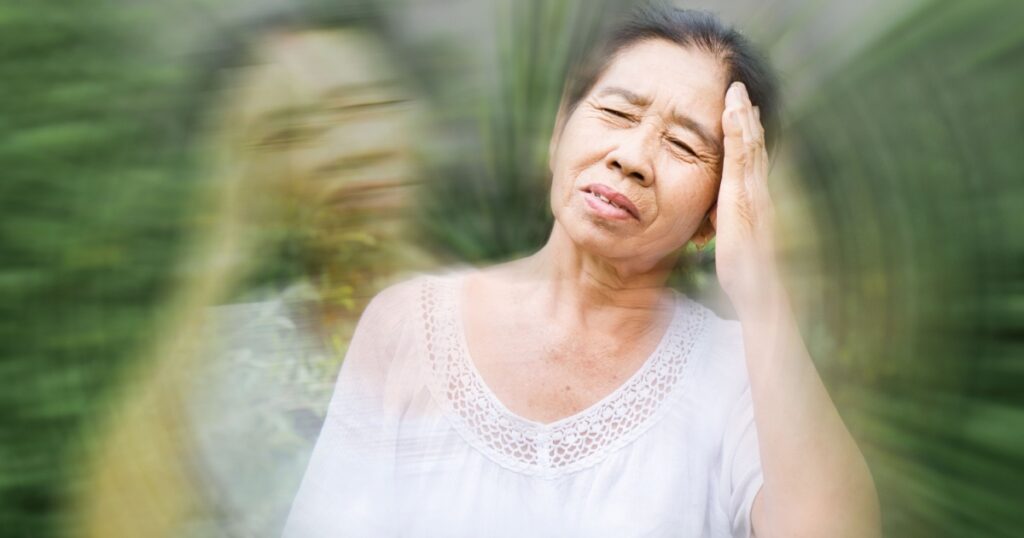old elderly Asian feeling faint and dizzy from hot weather