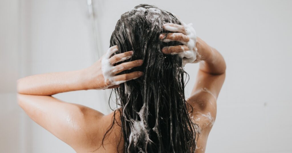 Woman washing hair with shampoo and shower in bathroom, Asian female body and hair care with foam to freshness. Spa and Health care.