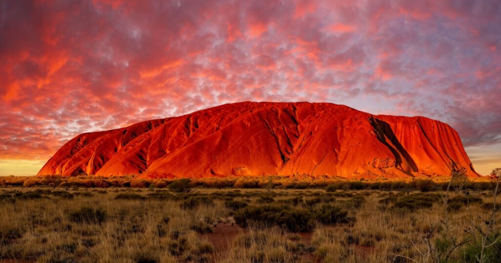 Uluru, Australia - March 19, 2023 - Sunset of Uluru, the famous gigantic monolith rock in the Australian desert. Image taken from the approved public viewing and photography area.