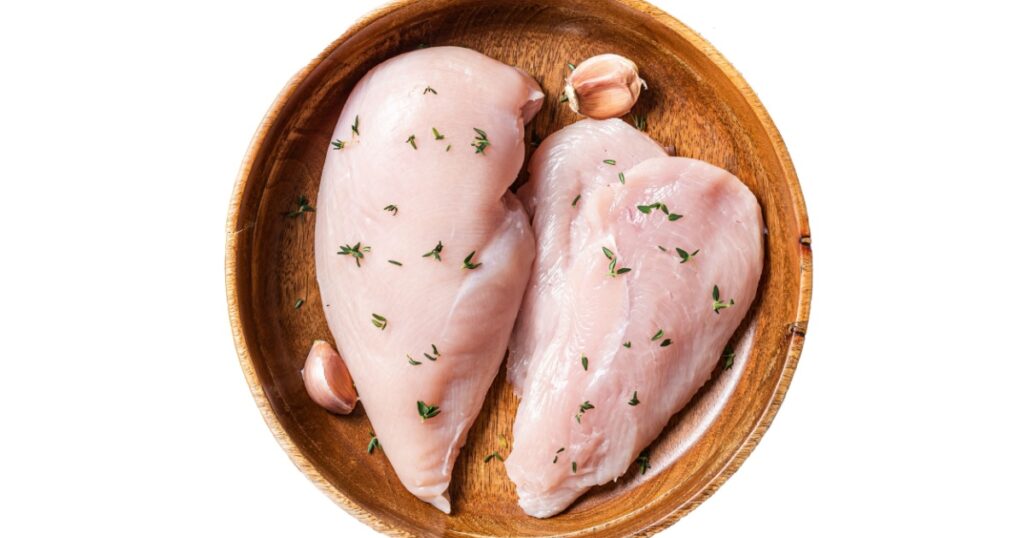 Sliced raw Chicken breast fillet, poultry meat steaks in plate. B Isolated on white background.