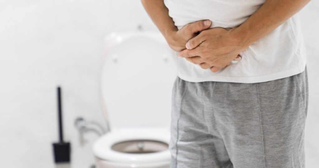 Men have stomachache and use their hands to hold their stomach In the bathroom. Constipation or colon cancer. diarrhea and severely toxic food. Man touch belly in the bathroom. Abdominal pain