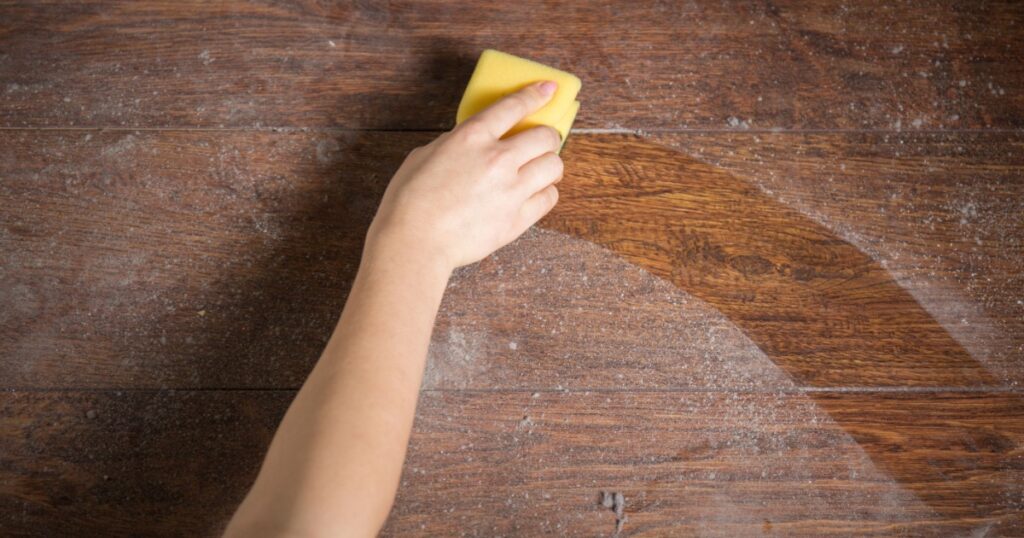 Using yellow sponge for cleaning dusty wood