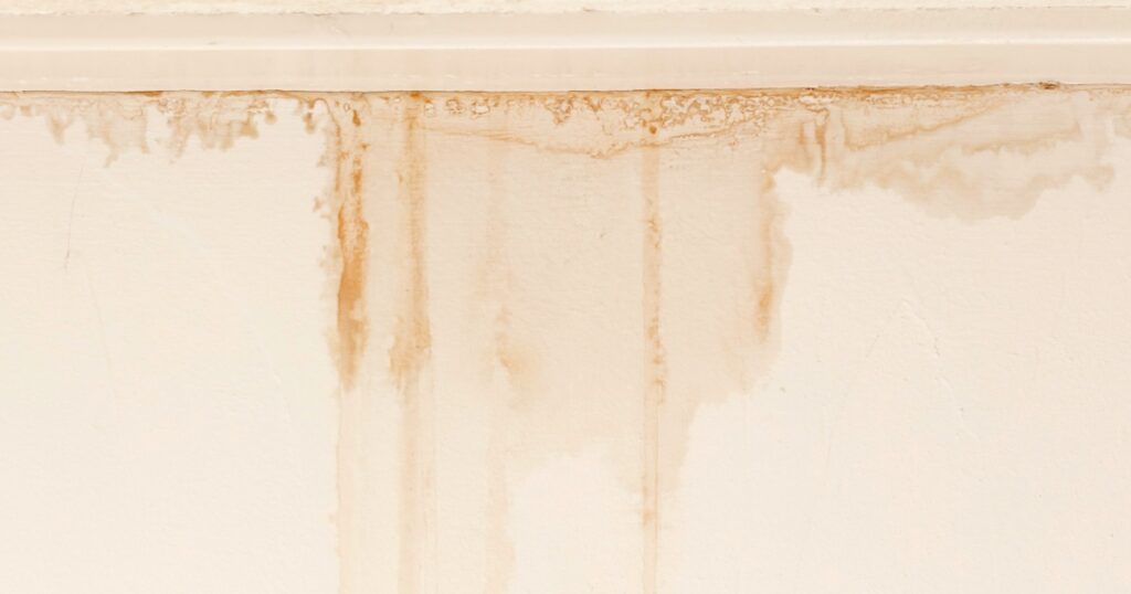 Water damaged ceiling and wall, white becomming brown