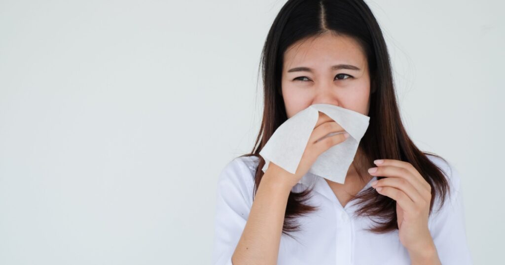 close up asian woman holding tissue in hand for reaction sneezing after got coronavirus disease for unhealthy life and protection coronavirus (covid 19) infection concept