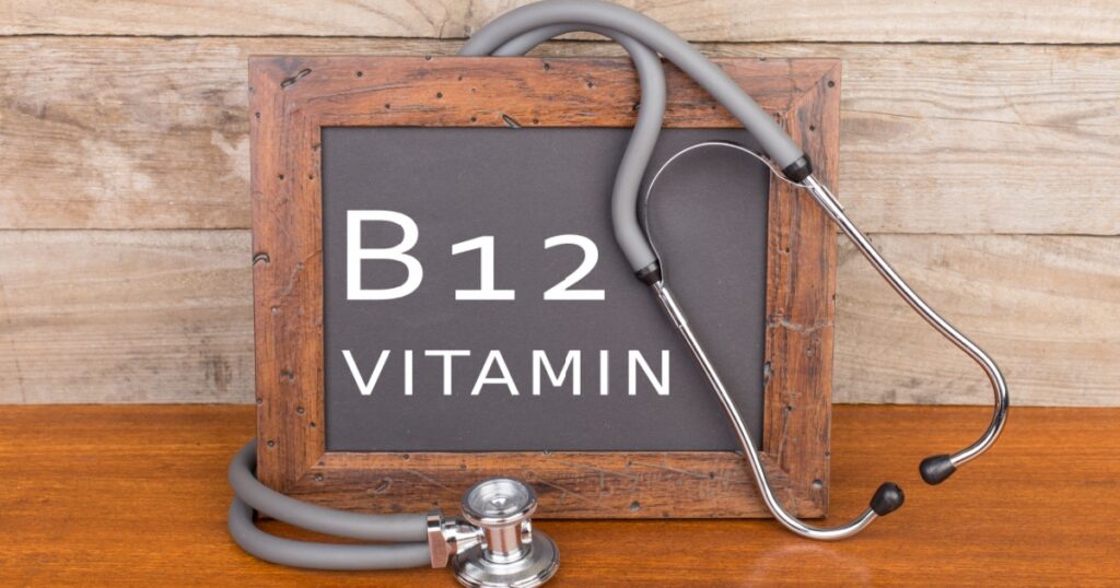 Medical concept - stethoscope and blackboard with text "Vitamin B12" on wooden background