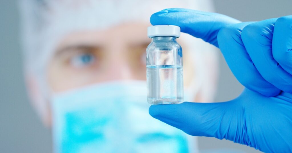 A doctor or scientist in laboratory holding a syringe with liquid vaccines for children or older adults, or cure animal diseases. Concept:diseases,medical care,science, anesthesia,euthanasia,diabetes.