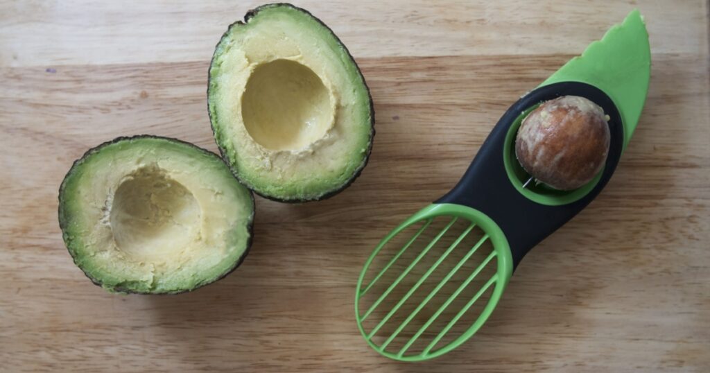 Avocado cut in half and pitted with three in one avocado preparation tool.