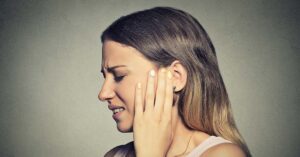 6 Signs You Have an Ear Infection and How To Help Prevent One woman in pain with hand placed over ear. ear infection symptoms concept