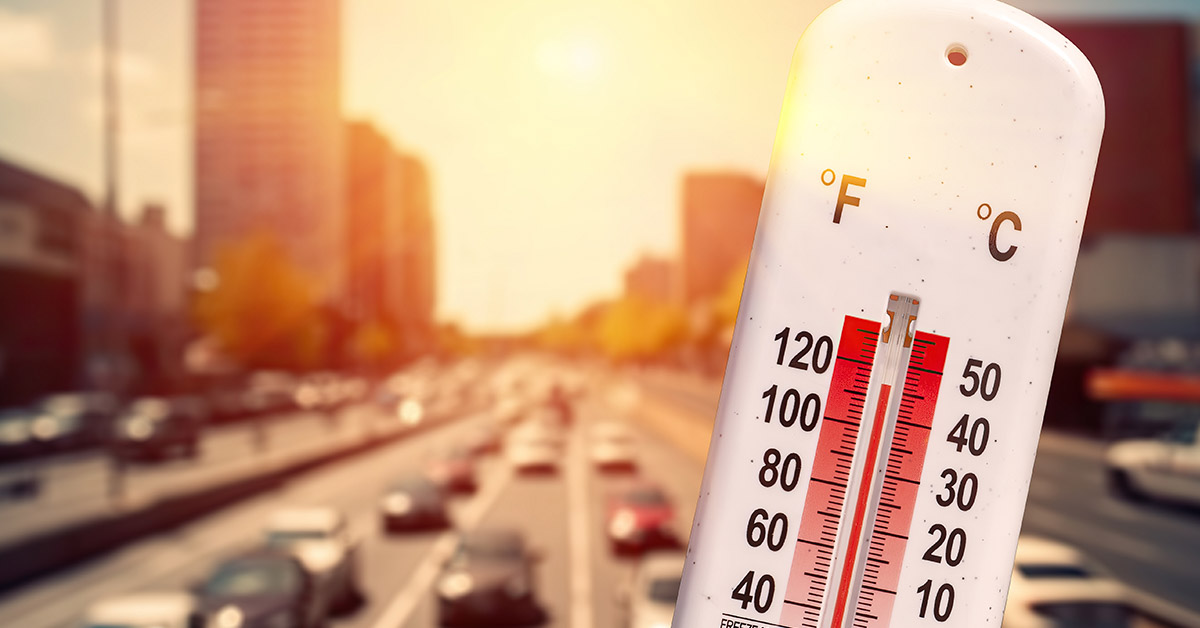 thermometer with sunlit city in background. High temperature concept