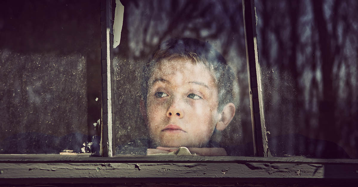 child looking out barred window