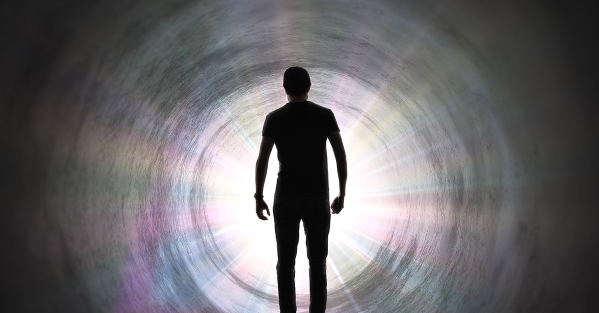 man walking down a tunnel with bright white light at the end of it. Afterlife concept. life after death concept