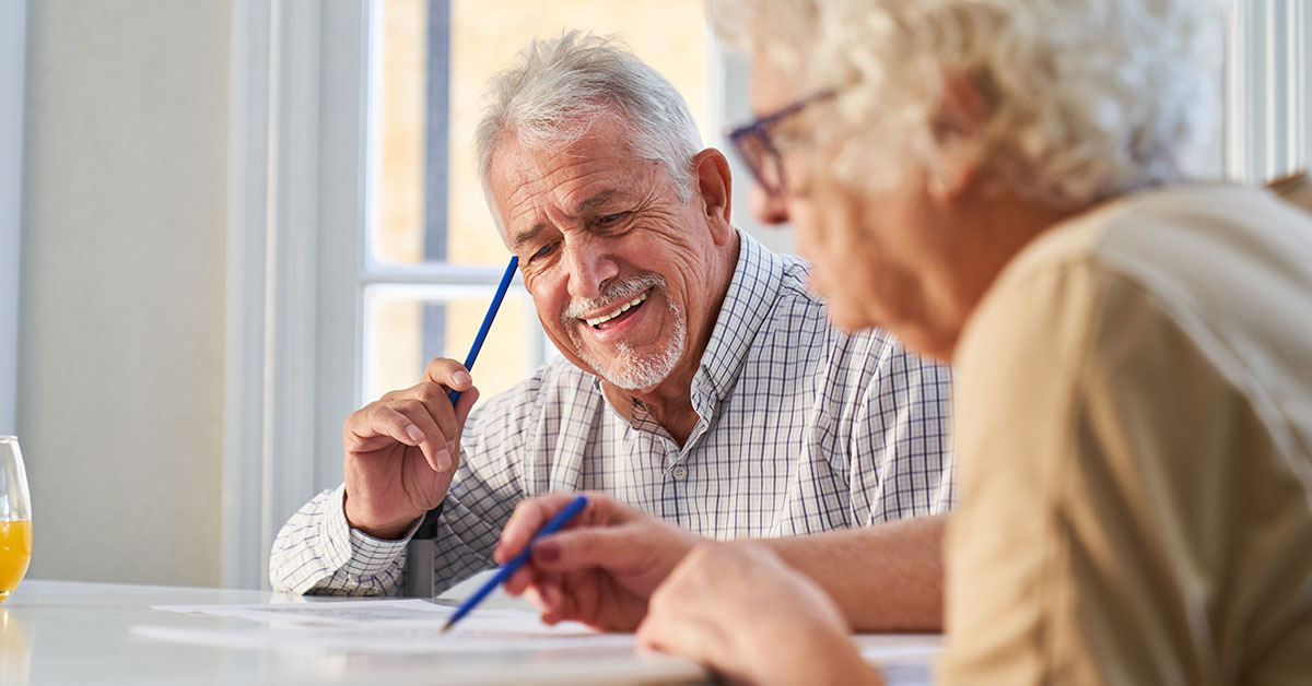 elderly couple doing paper work at table