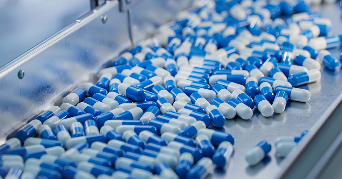 blue and white pills in factory production setting