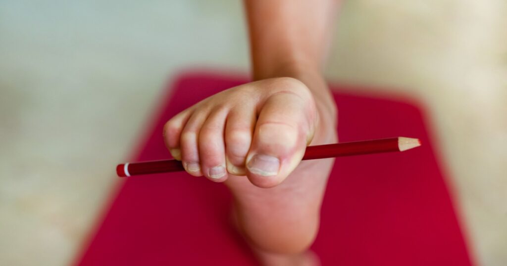 Girl doing exercises with a pencil for toes. Close-up. Special exercise for synchronized swimming