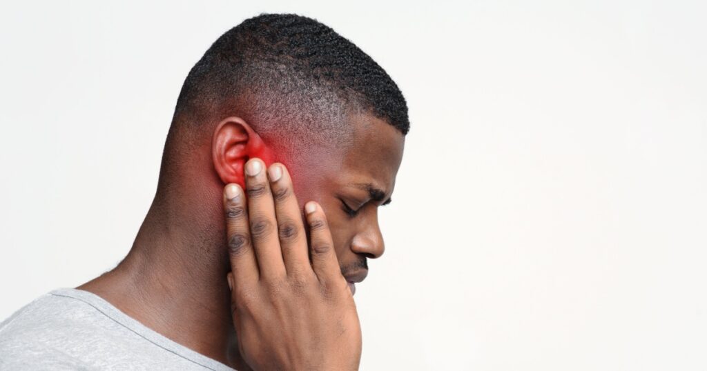 Tinnitus. Profile of sick back guy having ear pain, touching his painful head, copy space