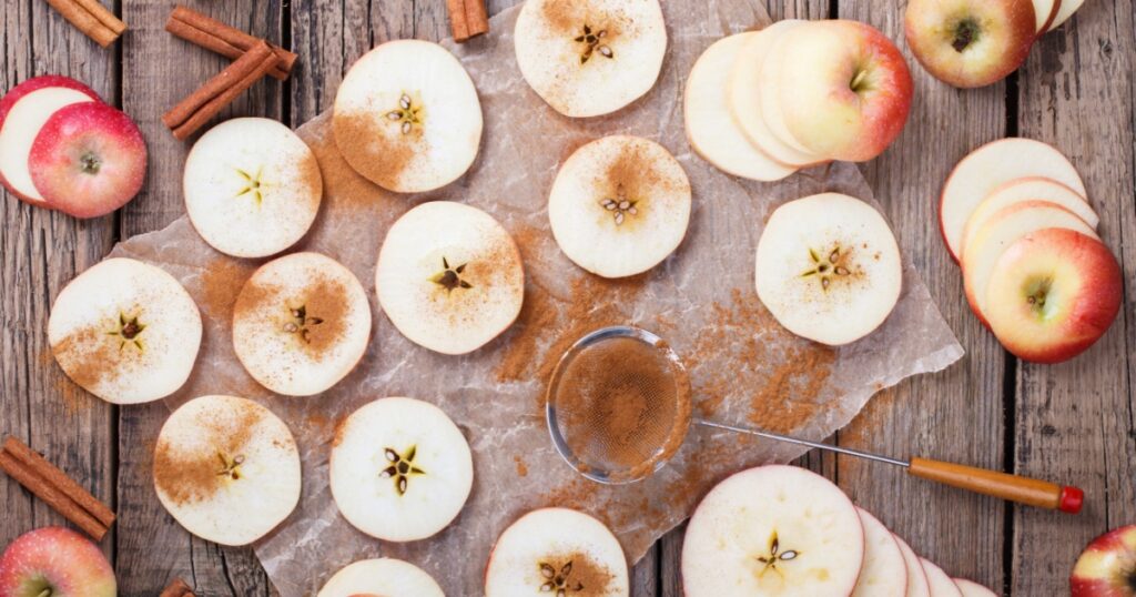 Apples sliced with cinnamon on old wooden background.selective focus.