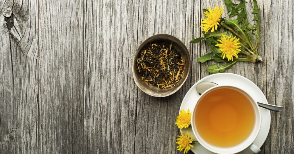 Cup of healthy dandelion tea on wooden background. Herbal medicine.