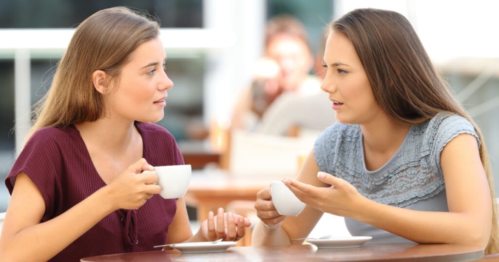 Two serious friends talking sitting in a restaurant