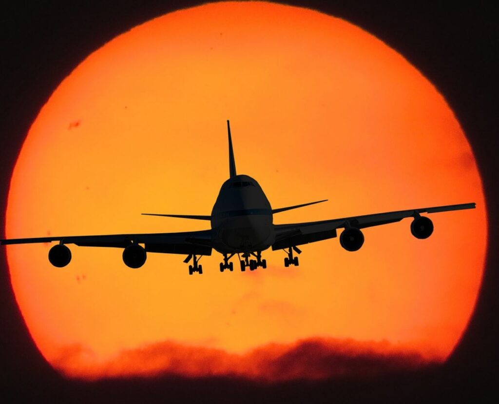 An airplane flying toward the sun.