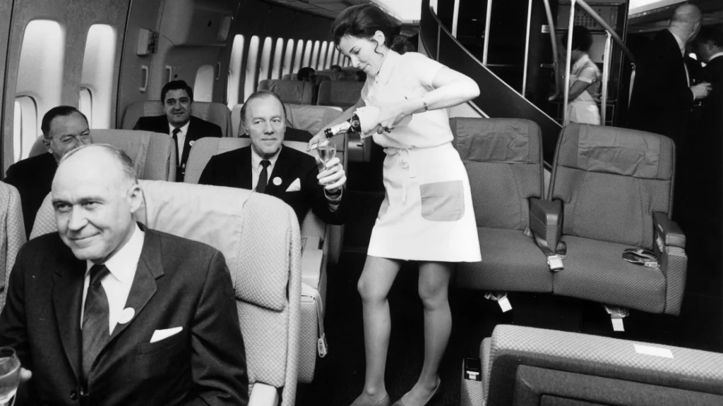 golden age of flying - A Pan Am flight attendant serves champagne in the first class cabin of a Boeing 747 jet