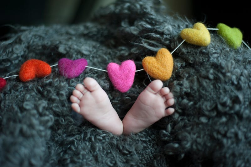 baby's feet under a heart string and a blanket