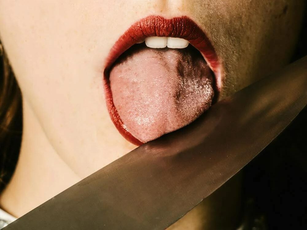 Woman With Red Lipstick Licking a Knife 